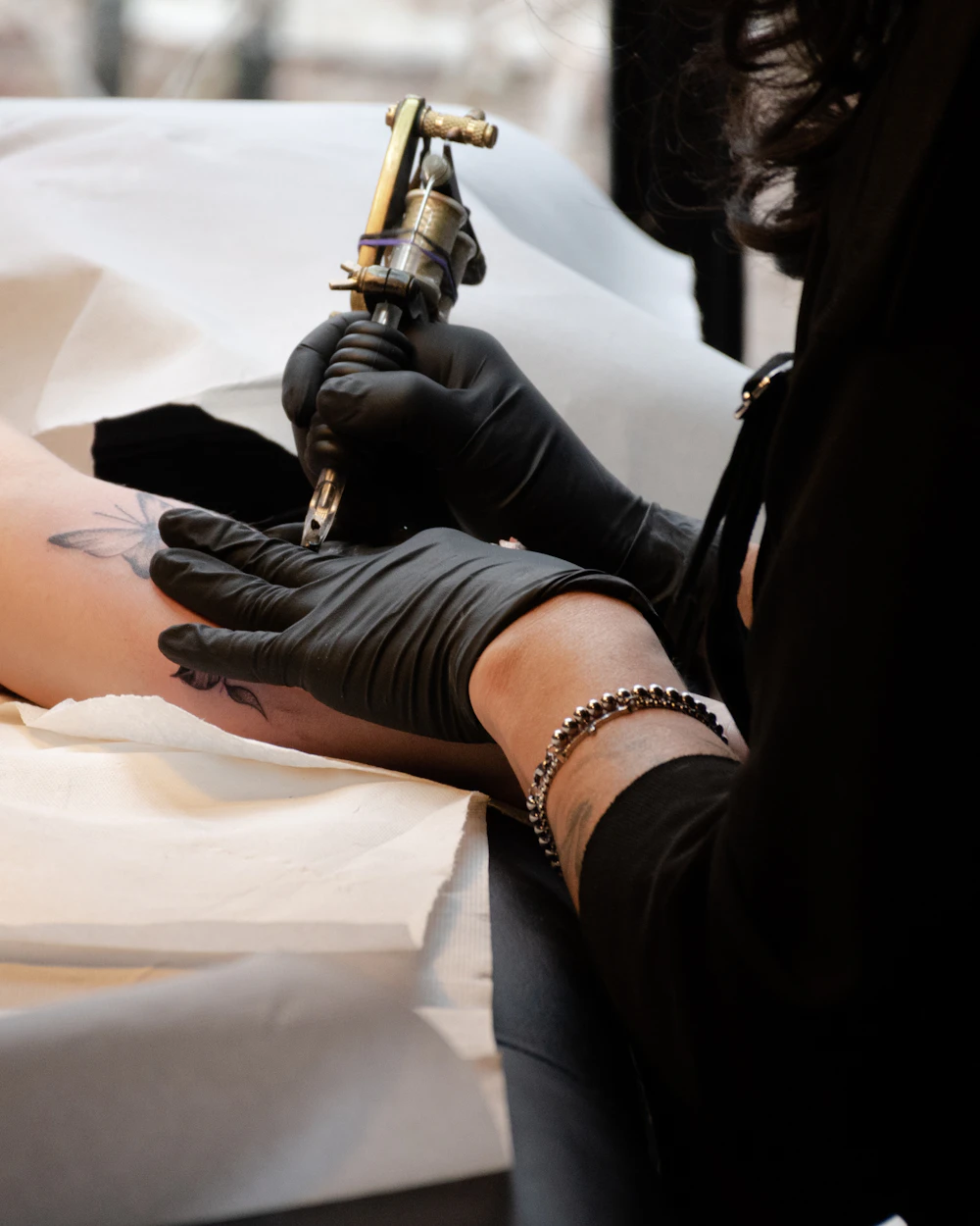 Gloved hands holding a micropigmentation machine