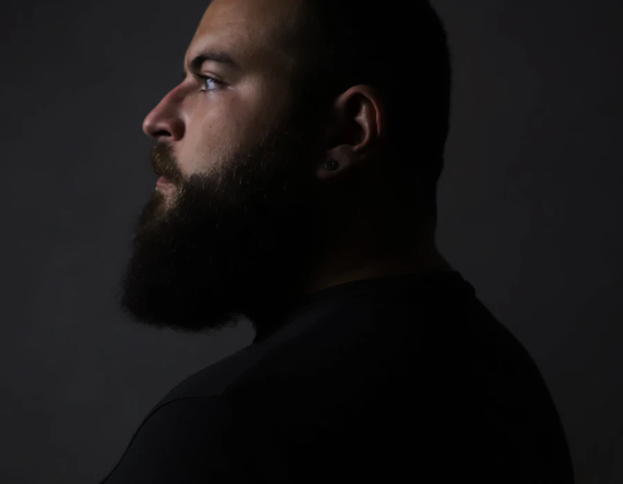 Bearded man in profile against a dark background